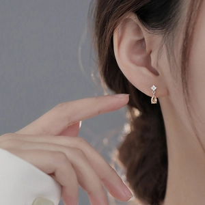 Detail of star-shaped stud with a champagne pear-cut zircon teardrop earring