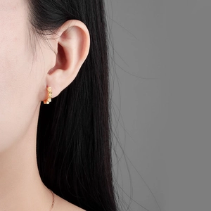 Boucles d'oreilles dorées géométriques avec zircons micro-incrustés sur mannequin