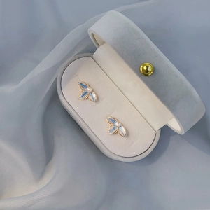Blue flower pearl stud earrings with gold trim displayed in a velvet jewelry box