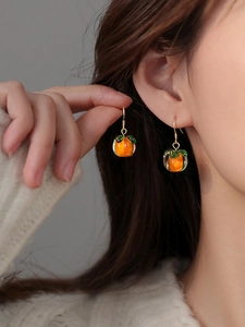 Detail of handmade orange persimmon drop earrings featuring crystal glass and gold hooks