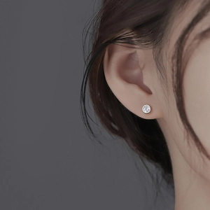 Classic S925 sterling silver stud earrings featuring round cubic zirconia on model ear