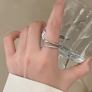 Detail view of stacked double-layer silver ring with hammered texture worn on index finger