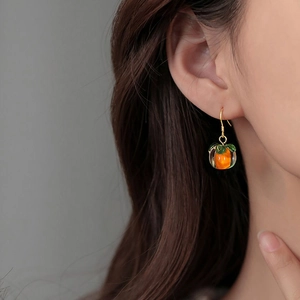 S925 silver persimmon drop earrings with orange resin and gold hooks on a model