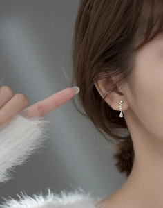 Close-up of elegant S925 silver pear-shaped zircon drop earrings worn by a model