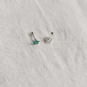 Detailed view of daisy enamel stud earrings with peacock green petals and screw backs