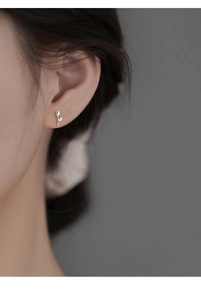 Close-up of S925 silver tulip stud earring with small cubic zirconia on model's ear