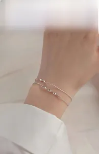 Close-up of a double-layer S925 silver Mobius bracelet worn on a female wrist