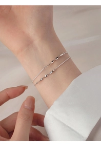 Detail of S925 sterling silver Mobius double-layered bracelet on female wrist