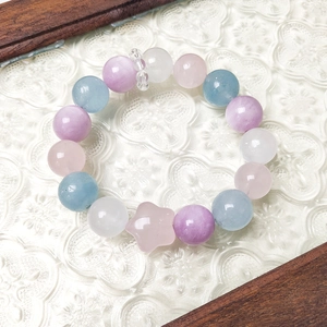 Pastel natural crystal beaded bracelet with kunzite and star charm on elegant background