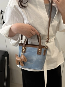 Bucket-Tasche aus blauem Denim und braunem Leder mit Anhänger und Textdruck