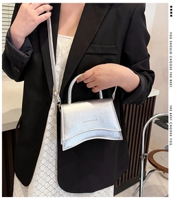 Détail de la texture en cuir argenté et de la base incurvée du sac à main mode