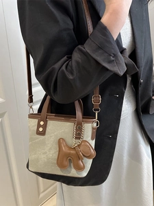 Retro-Eimer-Tasche aus Segeltuch mit Lederbesatz und Welpen-Anhänger am Modell