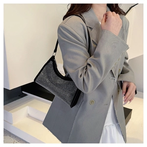 Detail einer funkelnden silbernen Strass-Schultertasche zu einem grauen Blazer