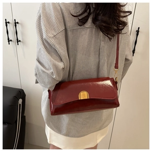 Vue détaillée du sac baguette vintage rouge foncé brillant avec fermoir en métal doré