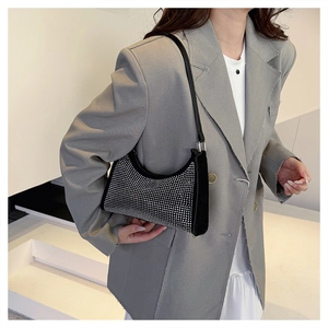 Detail einer schwarzen Hobo-Tasche mit schimmernden Silber-Strasssteinen und Lederriemen