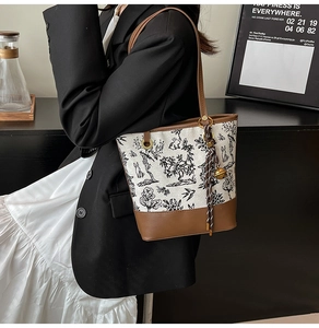 Detail of canvas tote bag featuring traditional Chinese ink painting and leather trim