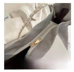 Close-up of golden metal zipper and texture on the large woven handle tote bag