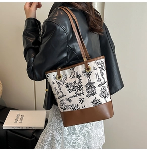Detail of vintage canvas tote bag featuring traditional ink floral patterns and leather trim