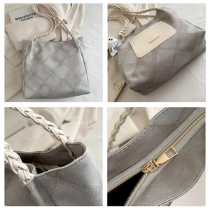Detail of the high-quality metal zipper and woven rope handle on a taupe quilted tote bag