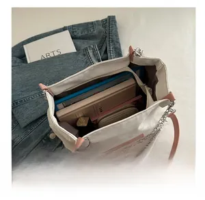 Interior view of large white canvas tote bag showing books and cosmetics storage