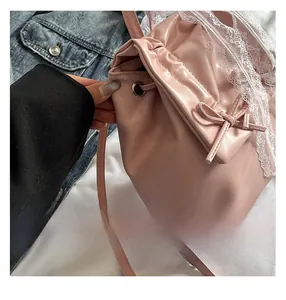 Dettaglio dello zaino rosa balletcore con pizzo delicato e fiocchi decorativi