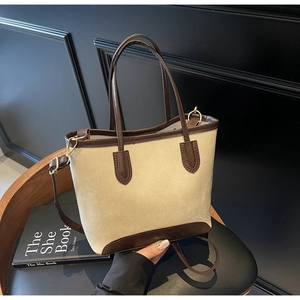 Detail of cream and dark brown contrast stitching leather tote with gold hardware