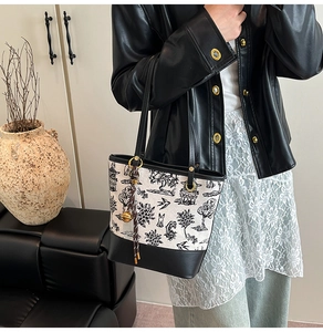 Detail of vintage tote bag with traditional ink painting and woven tassel charm