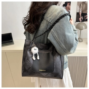 Dettaglio della borsa tote grigia trapuntata con tracolla intrecciata e logo moda