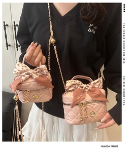 Detail of pink quilted mini bag with gold hardware, chain strap, and leopard silk scarf