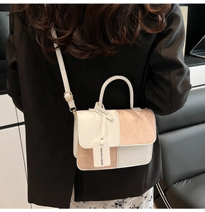 Detail of contrast color crossbody bag with adjustable strap and fashion label