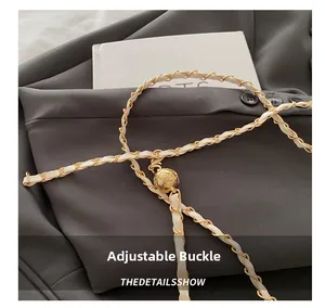 Detail showing gold chain belt with leather weave and adjustable spherical metal buckle