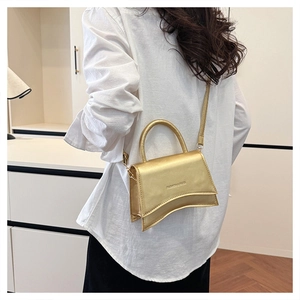 Détail d'un mini sac bandoulière doré métallisé avec une base incurvée design unique
