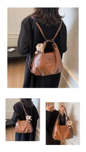 Detail of vintage brown leather bag showing versatile straps and plush pompom accessory