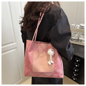 Dettaglio della borsa tote rosa in tela con tasca in pelle e ciondolo a orsetto