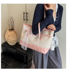 Macro detail of straw tote bag showing pink leather trim and white lace bow decoration
