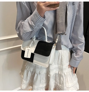 Top view of minimalist black and white leather handbag with fashion tag detail