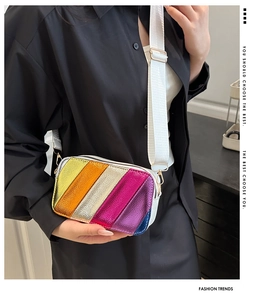 Detail of colorful metallic stripes and adjustable wide strap on the crossbody bag