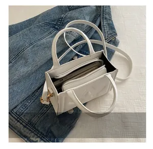 Interior view of white leather bag with star embossing showing phone and wallet capacity