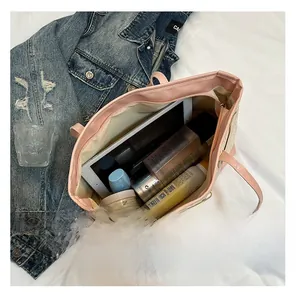 Spacious tote bag interior showing capacity for tablet and cosmetics with pink handles