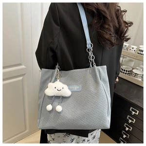 Detail of canvas tote bag with metal chain strap and cute cloud plush charm