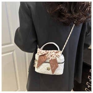 Vue de dos d'un mannequin portant un mini sac matelassé blanc avec nœud léopard doré