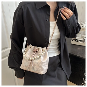 Detail of champagne bucket bag with floral jacquard fabric and pearl handle accents