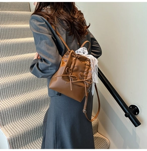 Vista posteriore dello zaino in pelle marrone stile balletto con fiocchi e nastro in pizzo bianco