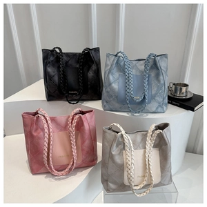 Detail view of large tote bags with quilted patterns and unique woven handles in four colors