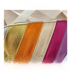 Detail shot of multi-color striped pebble leather mini bag with white zipper closure