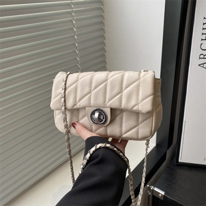 Elegant beige quilted crossbody bag with silver chain strap and metallic twist lock