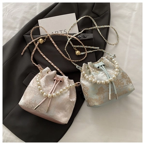 Detailed close-up of jacquard bucket bags with pearl handles and classic scenery patterns