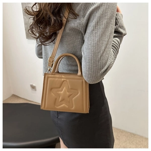 Detail of khaki square handbag with 3D star embossing and gold hardware strap buckle