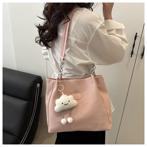 Close-up of pink textured tote bag with metal chain strap and cute cloud charm