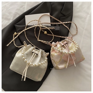 Detailed embroidery and pearl handle on vintage satin drawstring bucket bags